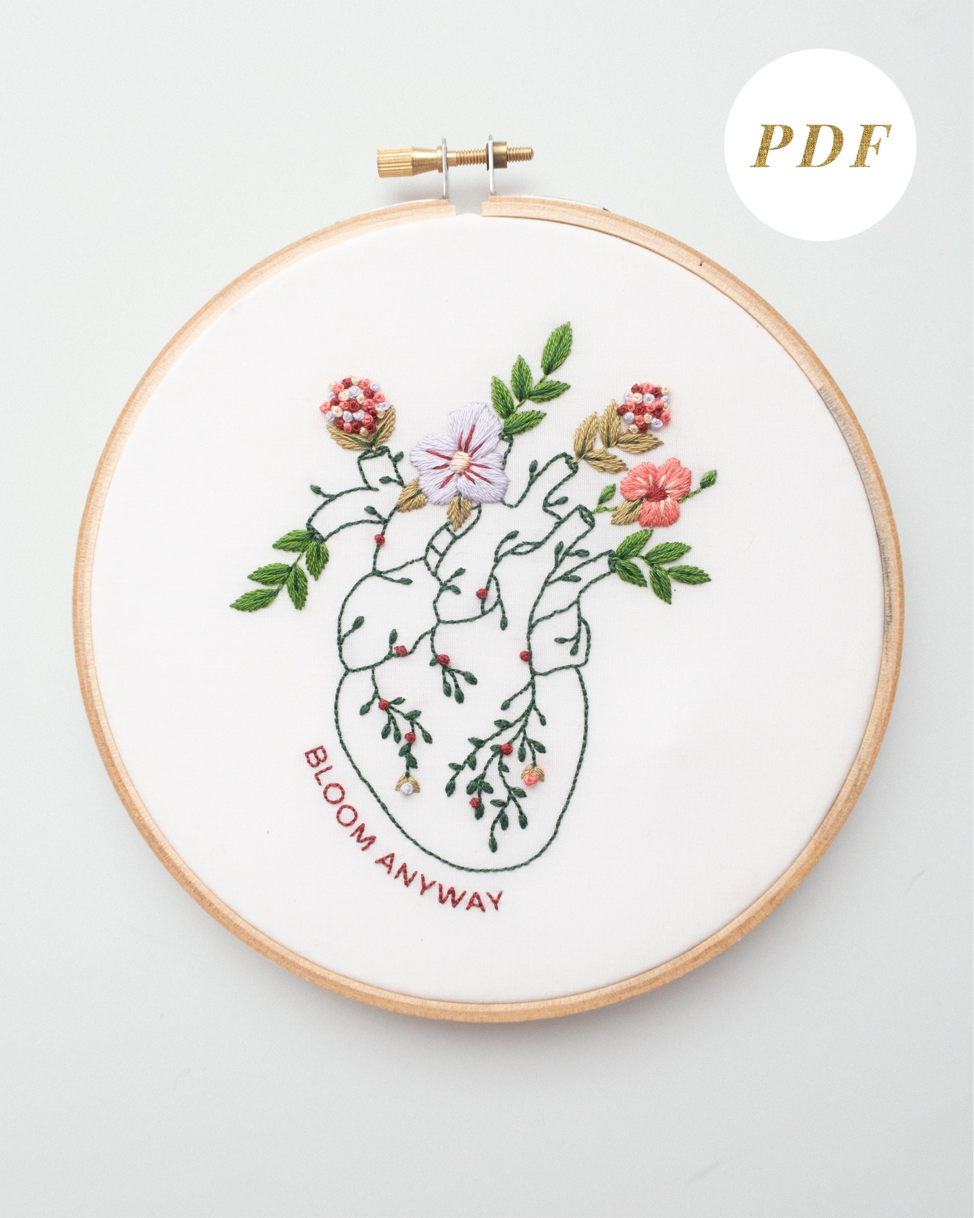 Bloom floral heart anatomy hand embroidery pattern for mental health with pink, purple and red flowers and green leaves completed
