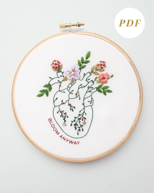 Bloom floral heart anatomy hand embroidery pattern for mental health with pink, purple and red flowers and green leaves completed