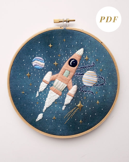 Pink rocket ship in outer space hand embroidery pattern for outer space nursery or decor with planets and stars