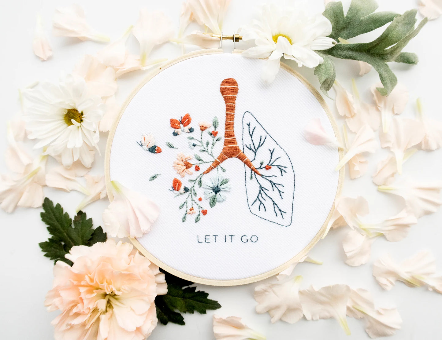 Let it go floral lung hand embroidery pattern with pink and blue flowers and butterflies for mental health craft on boho spring floral flat lay