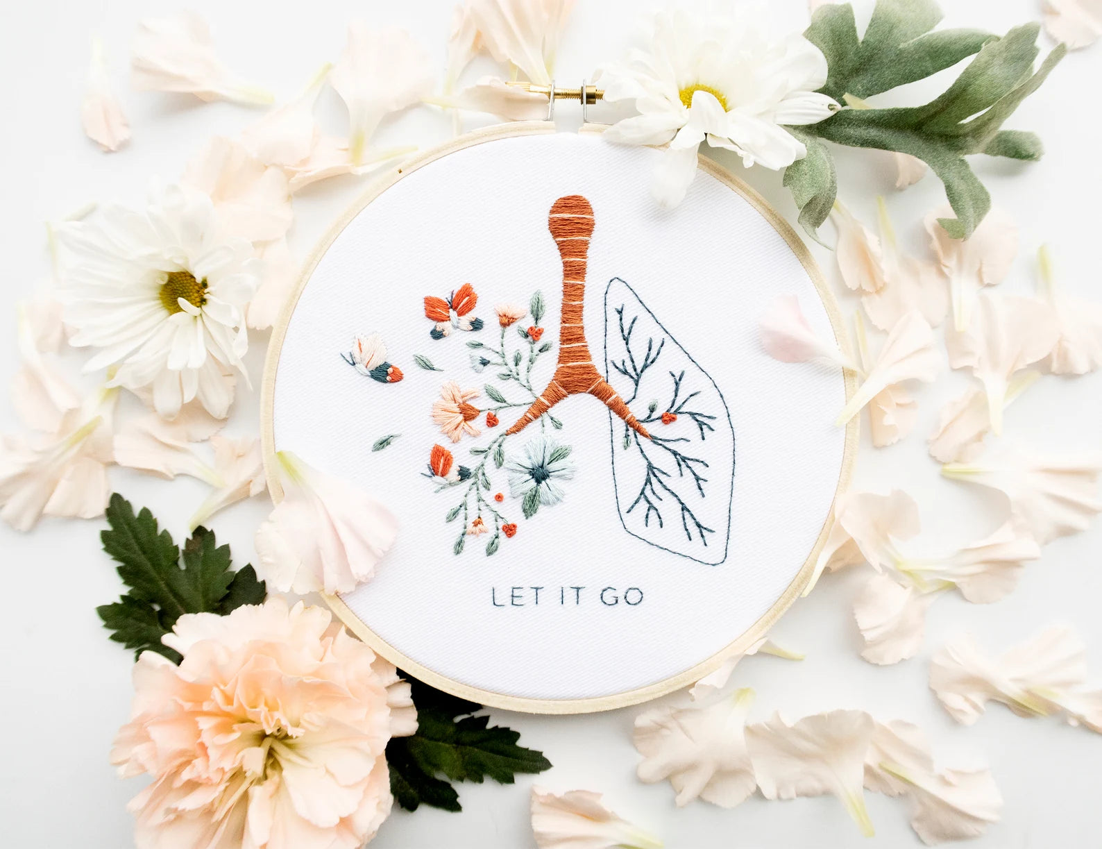 Let it go floral lung hand embroidery pattern with pink and blue flowers and butterflies for mental health craft on boho spring floral flat lay