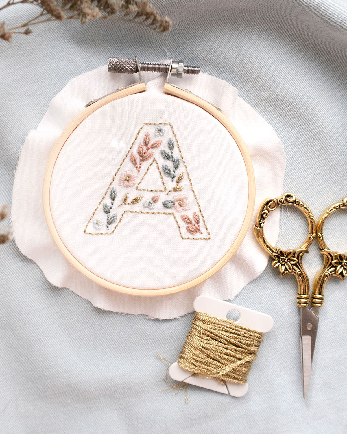 Floral Alphabet Embroidery Digital Pattern close up with golden thread and floral scissors