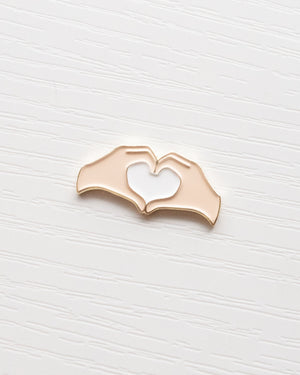 Heart Hands Embroidery Needle Minder close up on a white wooden background
