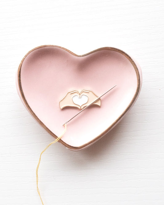 Heart Hands Embroidery Needle Minder in a heart shaped pink bowl