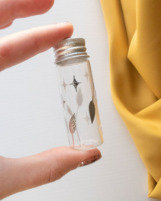 Silver Spark Embroidery Needle Holder being held between fingers