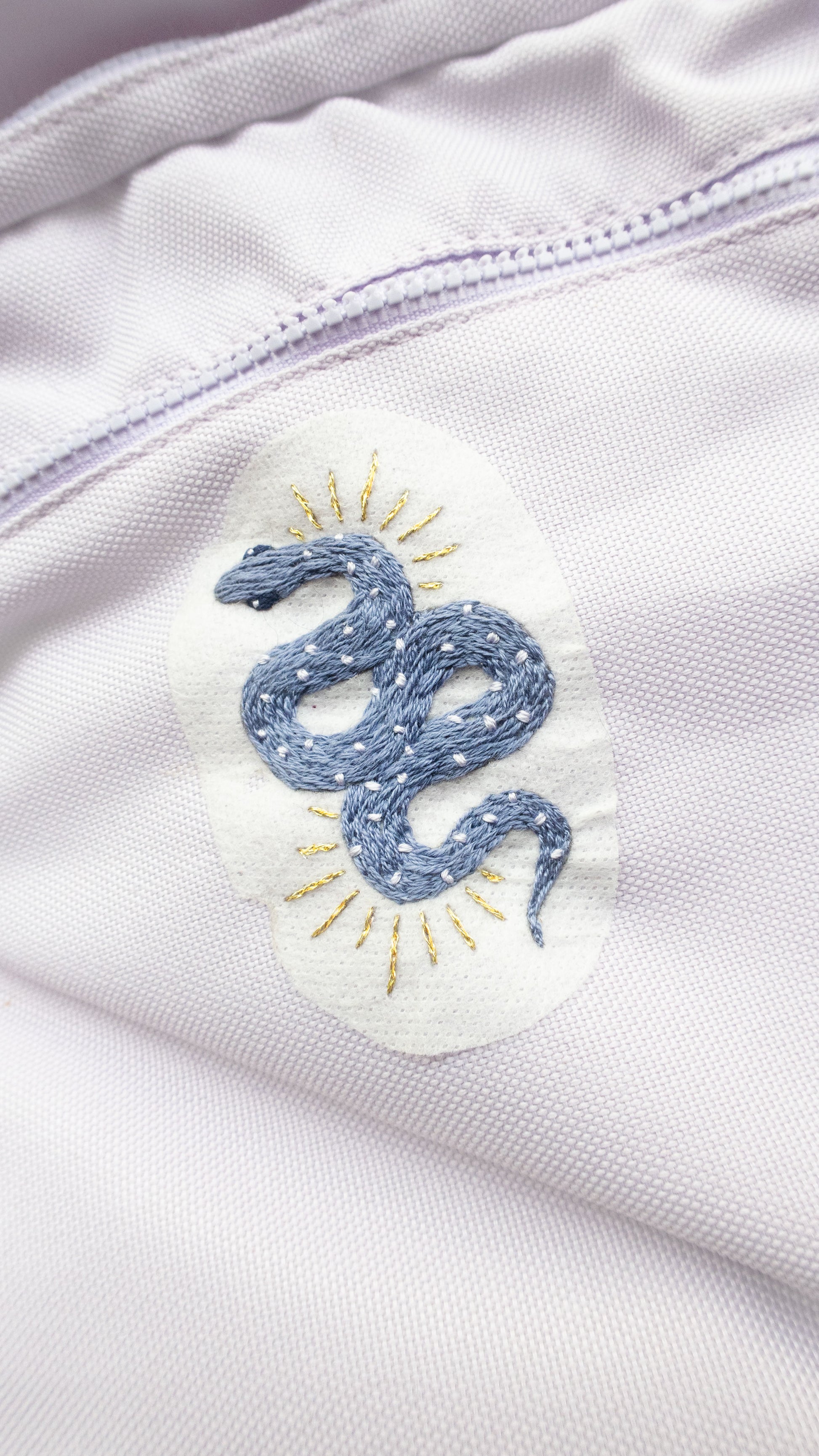 Southwest Hand Embroidery Stick and Stitch Pack with snake design embroidered blue on backpack