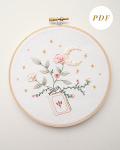 Embroidery pattern with open floral book with garden flowers and branches growing from open pages with stars and moon hand embroidery kit on embroidery hoop with boho dried florals