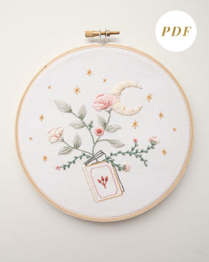 Embroidery pattern with open floral book with garden flowers and branches growing from open pages with stars and moon hand embroidery kit on embroidery hoop with boho dried florals