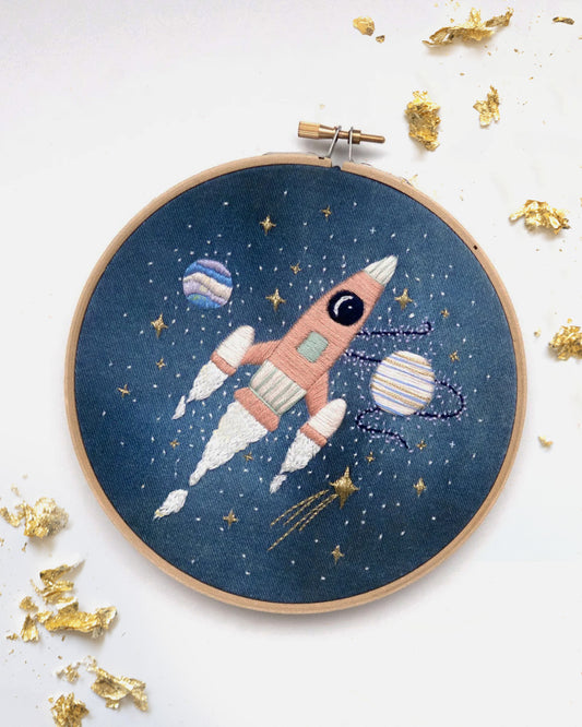 Pink rocket ship in outer space hand embroidery kit for outer space nursery or decor with planets and stars