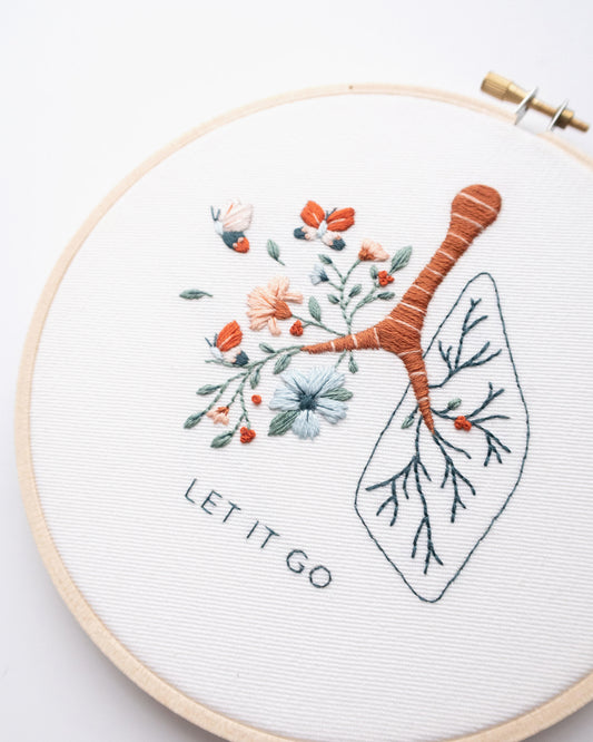 Let it go floral lung hand embroidery pattern with pink and blue flowers and butterflies for mental health craft close up of finished pattern