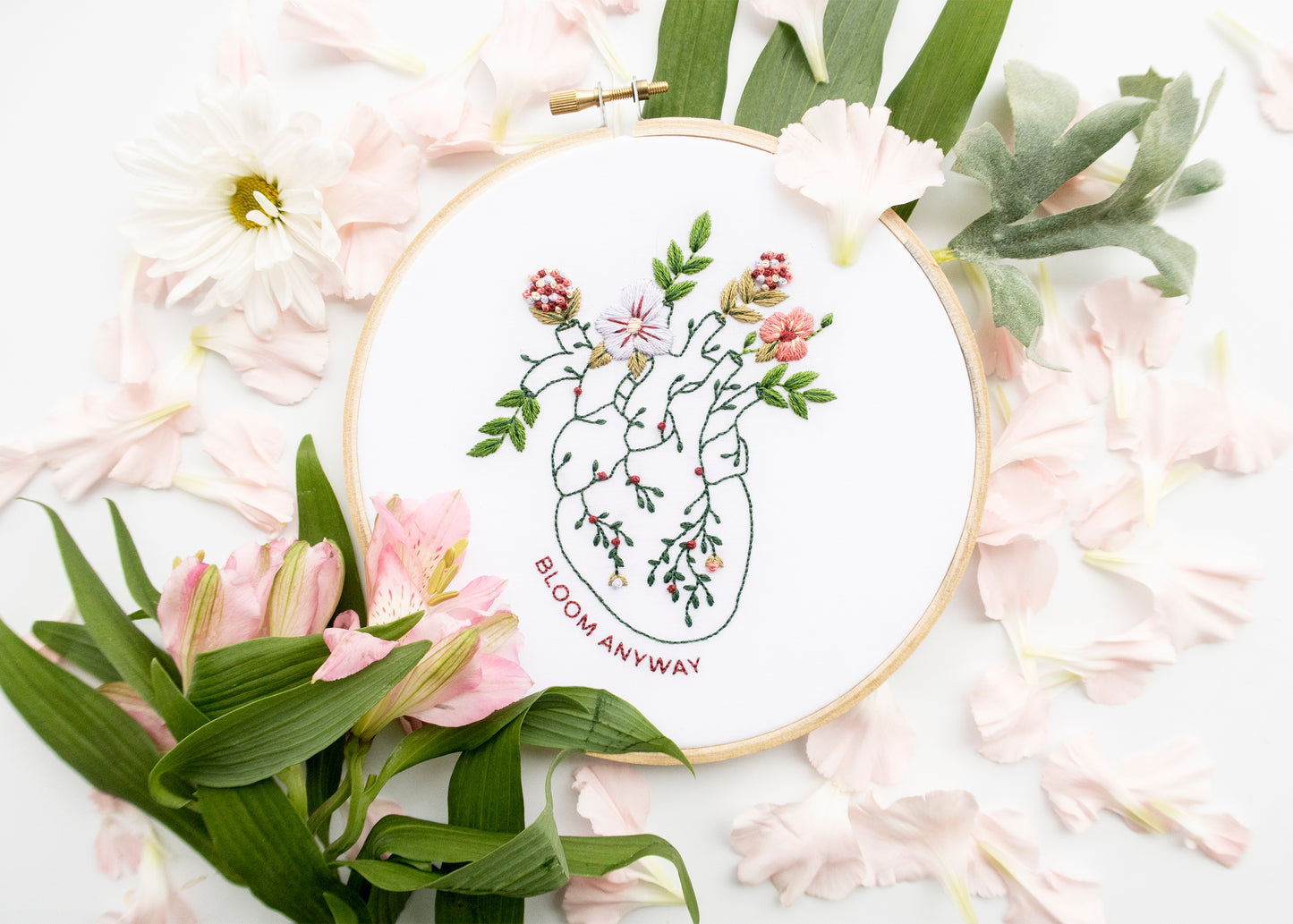 Floral anatomy hand embroidery pattern featuring floral hearth with Bloom Anyways mental health quote for mental health embroidery and beginner friendly embroidery with pink flowers and green plants