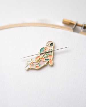 Pink and gold astronaut enamel needle minder or needle nanny on hand embroidery hoop with embroidery needle