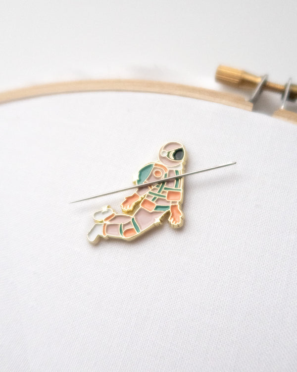 Pink and gold astronaut enamel needle minder or needle nanny on hand embroidery hoop with embroidery needle