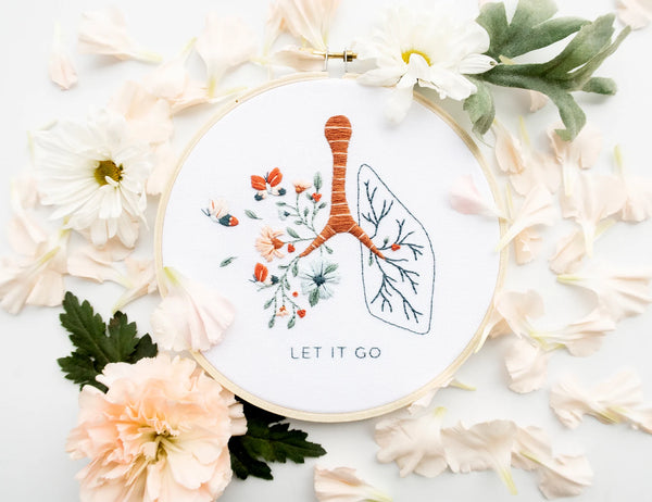 Let it go floral lung hand embroidery pattern with pink and blue flowers and butterflies for mental health craft on boho spring floral flat lay